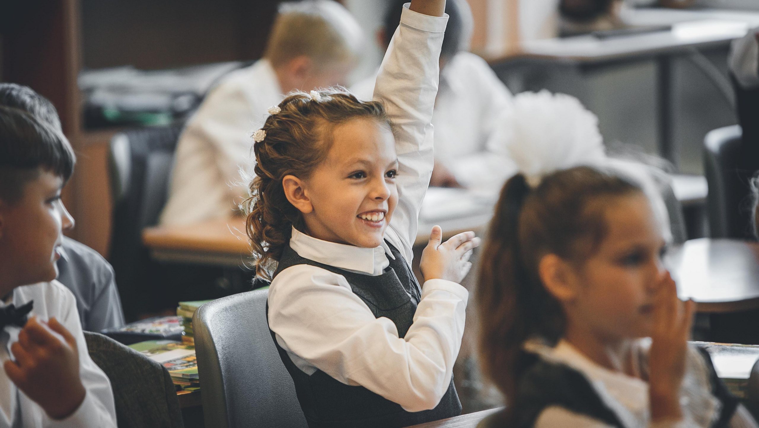 Girl attending school raising her hand